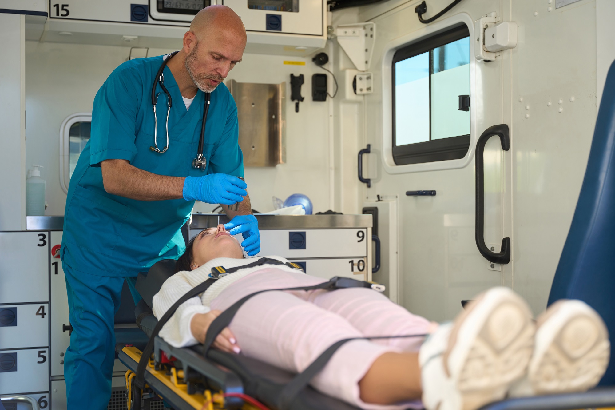 Doctor checks the reaction of the pupils of injured woman